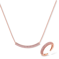 Rose gold jewelry set with pavé cubic zirconia stones including curved necklace, hoop earrings, and adjustable ring on cream background.
