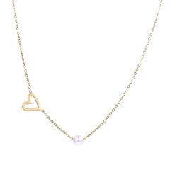 Delicate gold necklace with open heart charm and white pearl bead on fine chain against cream background