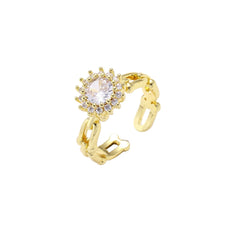 Two adjustable gold rings: chain-link band and halo-style ring with cubic zirconia stones on cream background