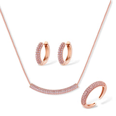 Rose gold jewelry set with pavé cubic zirconia stones including curved necklace, hoop earrings, and adjustable ring on cream background.