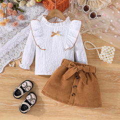 Weißes Mädchenkleid mit langen Ärmeln – Bluse mit Rüschenkragen und Zierborte, Cordrock mit großer Schleife und drei Knöpfen, eleganter Kinderrock