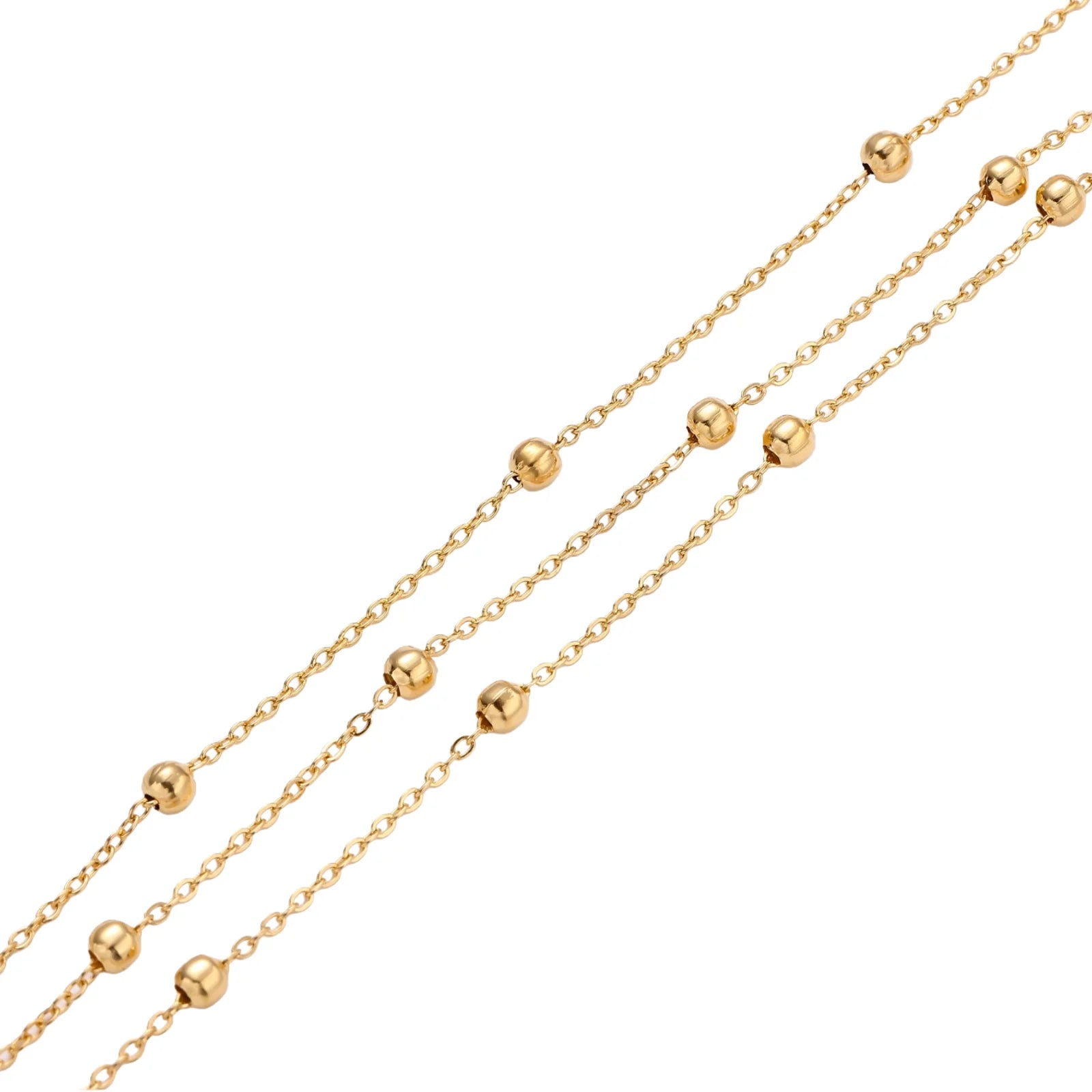 Three-strand gold-plated bracelet with clustered ball beads and adjustable clasp on cream background