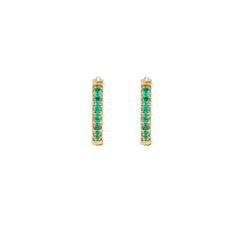 Pair of small gold huggie hoop earrings with bright green cubic zirconia stones on cream background